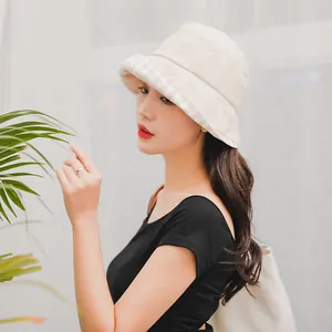 Detail of elegant beige bucket hat with stylish plaid pattern lining under the brim