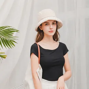 Close-up of a chic beige sun hat with checkered brim detail for women outdoors