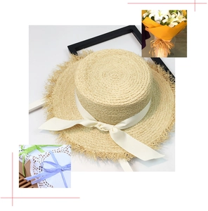 Detail of straw sun hat with raw edges, white ribbon bow, and natural woven texture