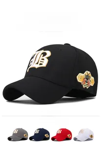 Detail of gold letter B embroidery and side bee patch on a cotton baseball cap