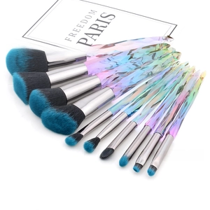 Detailed fan layout of 10-piece makeup brush set with crystal rainbow handles and blue tips
