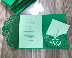 Macro detail of green laser-cut lace wedding invitation with intricate floral hollow pattern