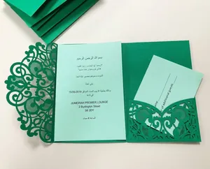 Macro detail of green laser-cut lace wedding invitation with intricate floral hollow pattern