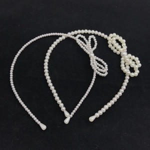 Detailed set of three white pearl headbands featuring diverse beaded bow designs on black