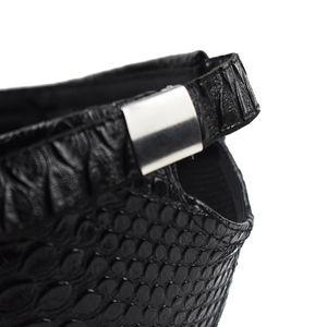 Detailed macro view of black faux crocodile skin texture and polished silver metal buckle