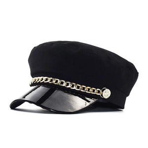Close-up of black baker boy hat with golden metal chain and glossy patent leather brim