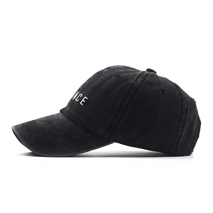 Detail of white 3D letter embroidery and vintage washed texture on black baseball cap