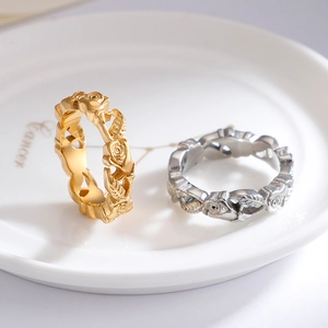 Exquisite rose flower relief ring in gold and silver finishes on a ceramic plate