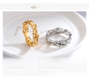 Close-up of rose flower rings in gold and steel finishes on a ceramic plate
