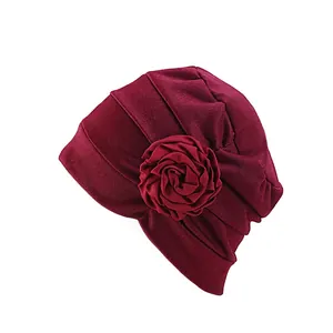 Détail du bonnet turban bordeaux avec fleur de rose et texture tricotée plissée