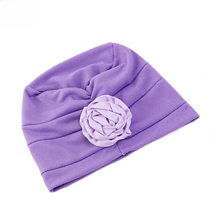 Détail d'un turban violet avec rose en tissu artisanale et texture douce côtelée