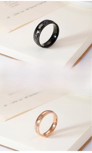 Detail view of engraved Her King and His Queen stainless steel crown rings with colorful stones