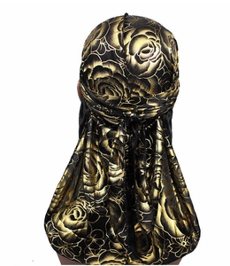 Detailed back view of a black silky durag with gold floral patterns on a white background