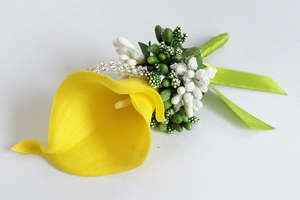 Detail of yellow calla lily boutonniere with white fillers and green ribbon wrap