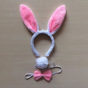 Three-piece plush rabbit ears headband set with pink bow tie and tail on wooden surface