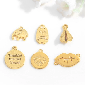 Detailed macro of gold animal and geometric pendants including elephant and owl shapes