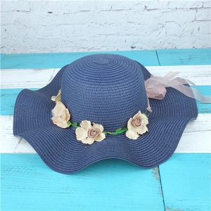 Chapeau de paille bleu marine à bord large avec guirlande de fleurs et rubans