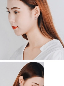 Detailed close-up of crystal leaf climber earrings worn on model's ear