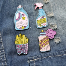 Macro shot of colorful enamel metal pins with humor text on blue denim fabric