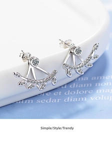 Macro shot of leaf earrings with crystal studs and curved silver branch pendants
