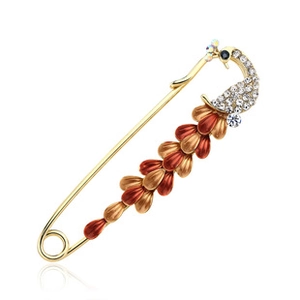 Detail view of golden peacock brooch with sparkling crystals and red feathers