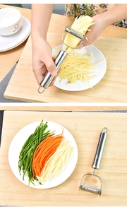 Dual-head stainless steel peeler shredding potatoes on a wooden kitchen board
