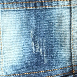 Close-up of vintage distressed denim dog vest with dual stitching and worn details