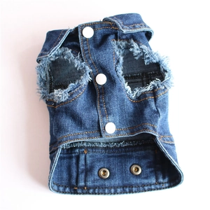 Detailed close-up of retro frayed edges and white resin snaps on a blue denim pet vest