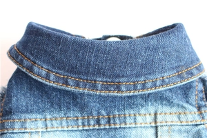 Detail view of vintage blue denim dog vest featuring sturdy stitching and retro fabric texture