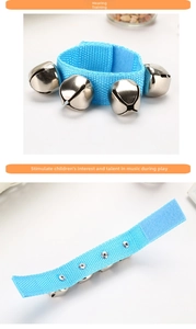 Close-up of blue wrist bell toy with four silver metal bells and adjustable velcro strap