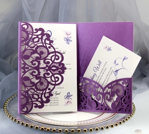 Macro detail of purple laser-cut wedding invitation with intricate lace floral patterns
