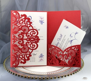 Detail of red laser-cut wedding invitation with white insert card on elegant display