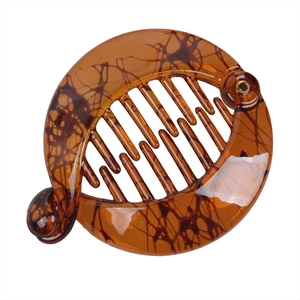 Close-up of tortoise shell round banana hair clip with interlocking teeth design