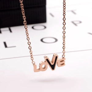Close-up of rose gold LOVE letter pendant with black inlay on a delicate cable chain