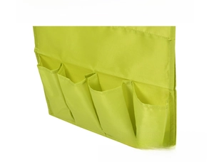 Detailed view of green hanging bedside organizer with four pockets for bedroom storage