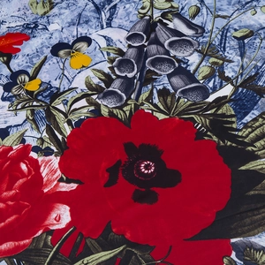 Close-up of silk twill fabric with vibrant red poppy and floral prints on blue background
