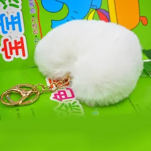 Detail shot of a soft white plush heart keychain with a premium golden metal ring