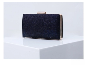 Detailed close-up of dark purple glitter clutch with gold metal frame and top square clasp
