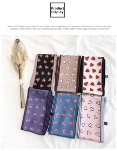 Detailed flat lay of six heart-patterned satin twilly scarves in assorted pastel colors