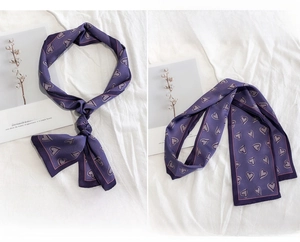 Detail of purple silk neckerchief showing heart print pattern and smooth fabric texture