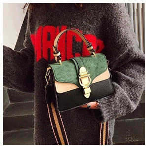 Close-up of tricolor crossbody bag with gold buckle and striped fabric shoulder strap