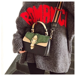 Detail of color-block crossbody bag with suede flap and striped woven shoulder strap