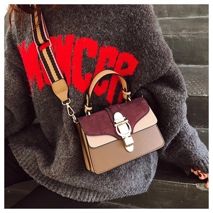 Detail of color-block crossbody bag with burgundy suede and metallic lock closure