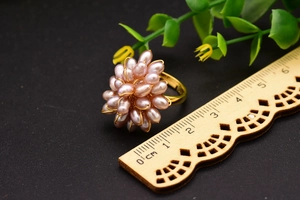 Vue détaillée d'une bague fleur en perles mauves de 3cm avec anneau doré et une règle