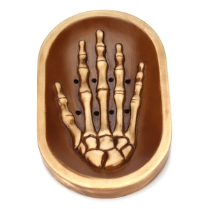 Macro detail of skull hand soap dish showing aged resin bone texture and drainage holes