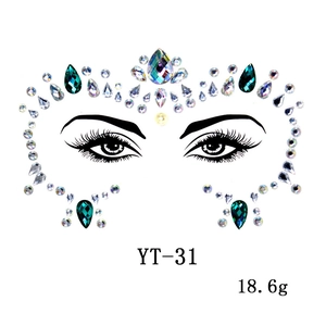Detail view of emerald and pearl face gems with symmetrical layout on clear backing