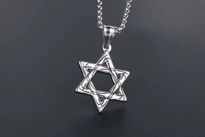 Macro detail of vintage hollow hexagram pendant made of polished silver titanium steel