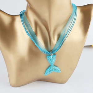 Detail of turquoise mermaid tail pendant with glitter resin and ribbon wax cord necklace
