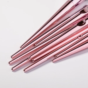 Close-up of rose gold tapered makeup brush handles with sleek metallic finish