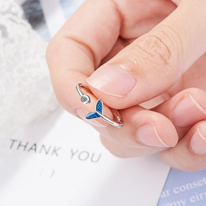 Silver ring with blue fishtail design and sparkling zircon stone shown in a lifestyle view